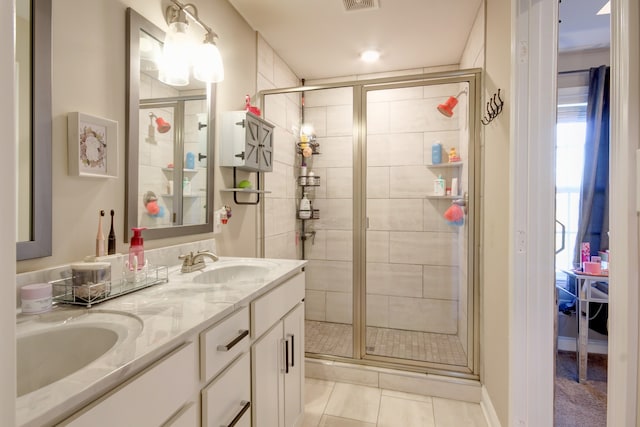 bathroom with tile patterned floors, a shower with door, and vanity