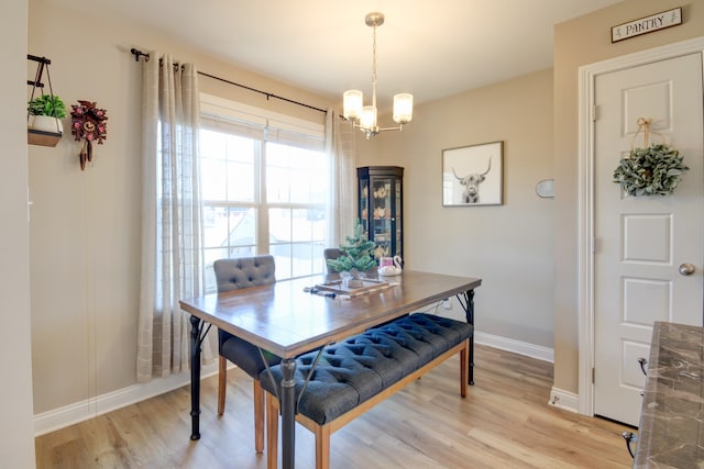 dining space featuring light hardwood / wood-style floors and an inviting chandelier