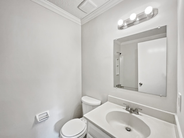 bathroom with vanity, ornamental molding, a textured ceiling, and toilet