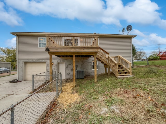 rear view of property featuring central AC unit, a garage, and a wooden deck