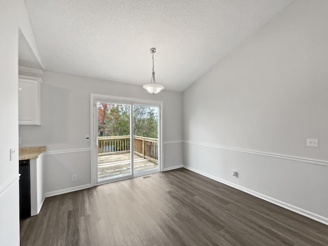 unfurnished dining area featuring dark hardwood / wood-style floors and a textured ceiling