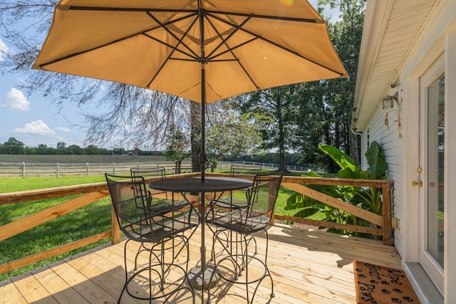 wooden deck featuring a rural view and a lawn