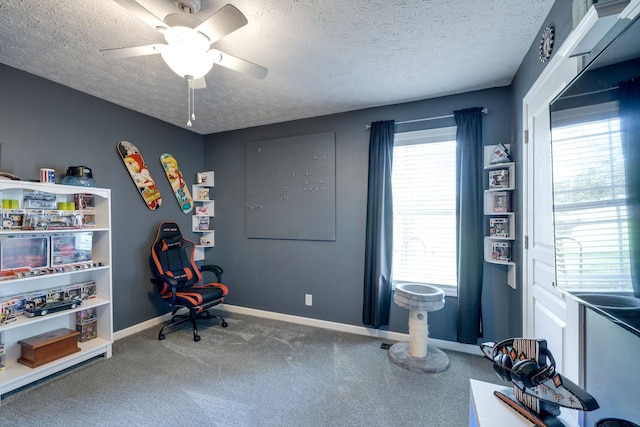 interior space with ceiling fan, a wealth of natural light, a textured ceiling, and carpet flooring