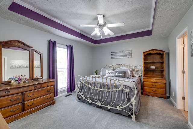 bedroom with a raised ceiling, ceiling fan, light carpet, and a textured ceiling