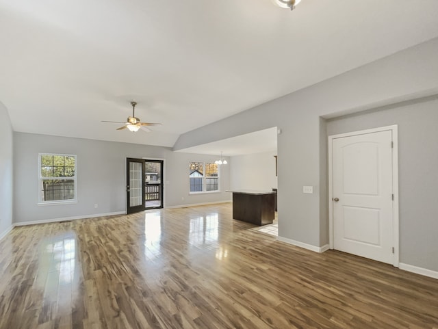 unfurnished living room featuring hardwood / wood-style flooring, plenty of natural light, and vaulted ceiling