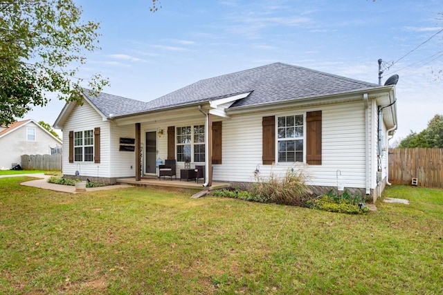 back of property with covered porch and a yard