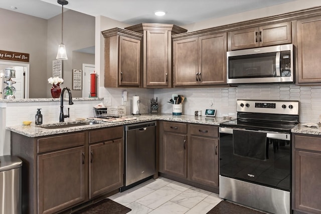 kitchen with stainless steel appliances, sink, light stone counters, and decorative backsplash