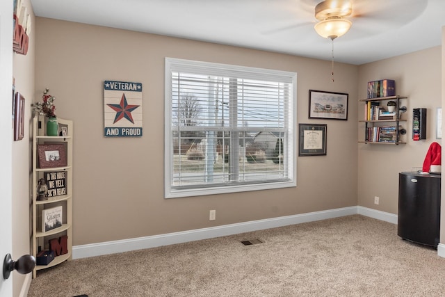 interior space with ceiling fan and light colored carpet