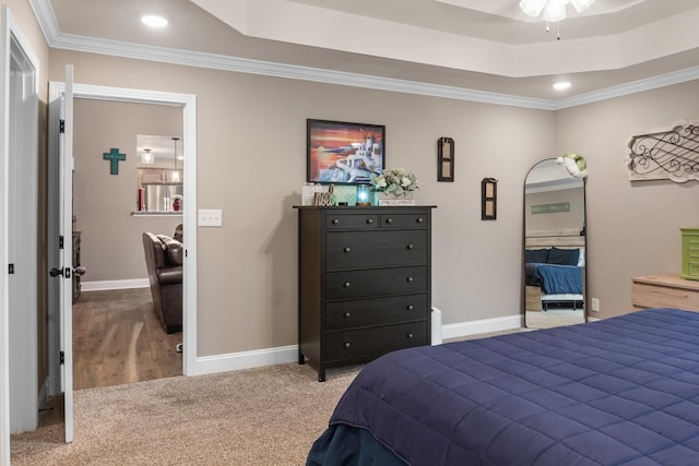 bedroom with crown molding, carpet flooring, and a tray ceiling