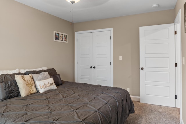 bedroom with ceiling fan, dark carpet, and a closet