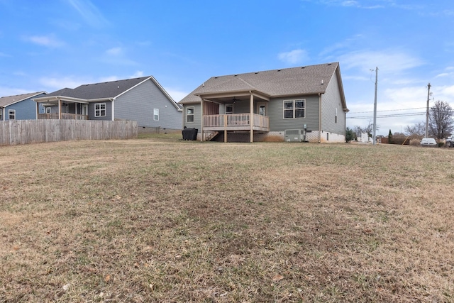 back of property with a yard and a deck