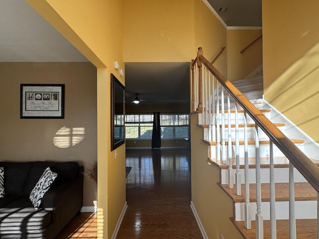 stairway with wood-type flooring and ornamental molding