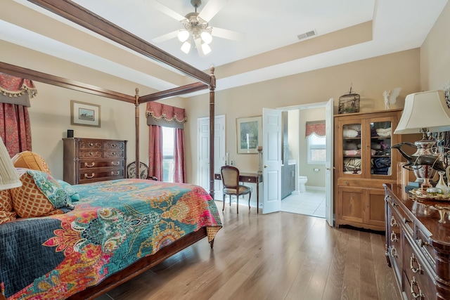 bedroom featuring ensuite bathroom, ceiling fan, and light wood-type flooring