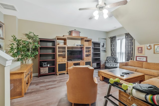 living room with light hardwood / wood-style flooring and ceiling fan