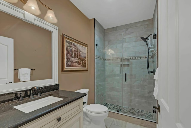 bathroom with an enclosed shower, vanity, and toilet