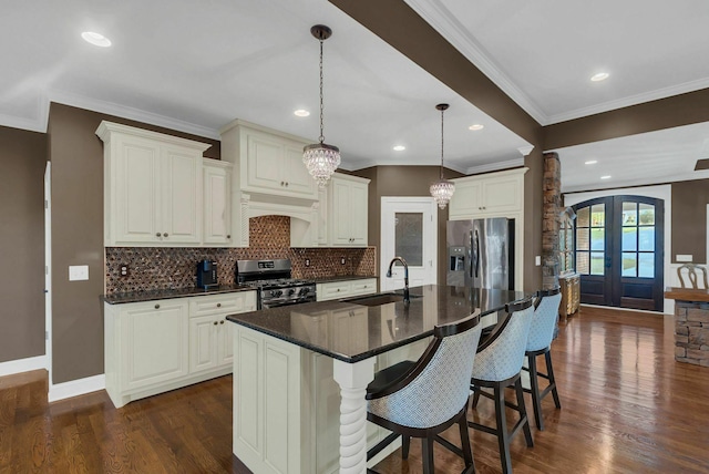 kitchen featuring french doors, a center island with sink, sink, dark hardwood / wood-style floors, and stainless steel appliances