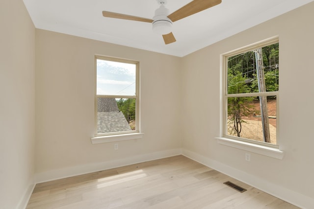 empty room featuring ceiling fan, light hardwood / wood-style floors, and a wealth of natural light