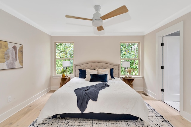 bedroom with ceiling fan, crown molding, and light wood-type flooring