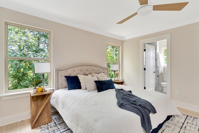 bedroom with ceiling fan, light wood-type flooring, ensuite bathroom, and ornamental molding