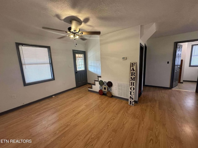 entryway with ceiling fan, a textured ceiling, and light hardwood / wood-style flooring