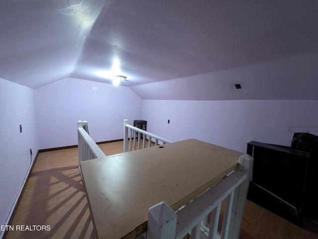 additional living space with hardwood / wood-style flooring and lofted ceiling