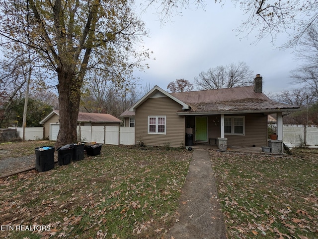 view of front of house featuring a garage, an outdoor structure, and a front yard