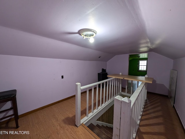 additional living space with lofted ceiling and hardwood / wood-style flooring