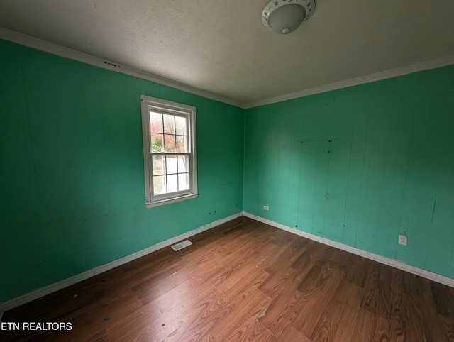 empty room with wood-type flooring and ornamental molding