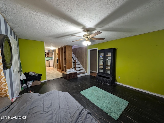 bedroom featuring ceiling fan, dark hardwood / wood-style floors, and a textured ceiling