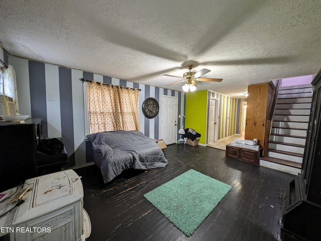 bedroom featuring multiple windows, ceiling fan, dark hardwood / wood-style flooring, and a textured ceiling