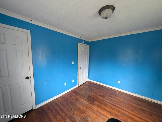 unfurnished bedroom with dark hardwood / wood-style floors, ornamental molding, and a textured ceiling