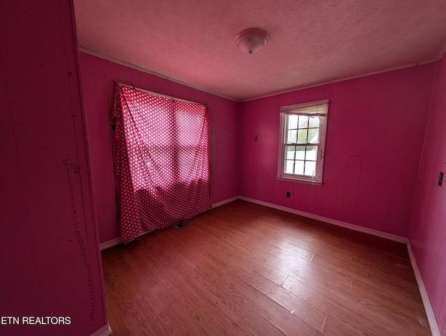 unfurnished room with wood-type flooring and a textured ceiling