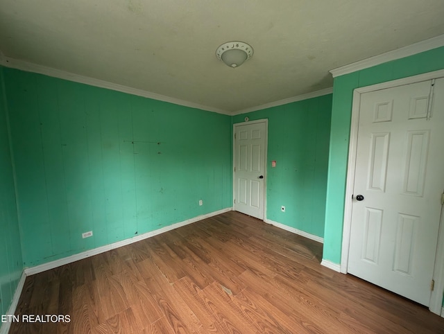 unfurnished bedroom with hardwood / wood-style flooring and ornamental molding