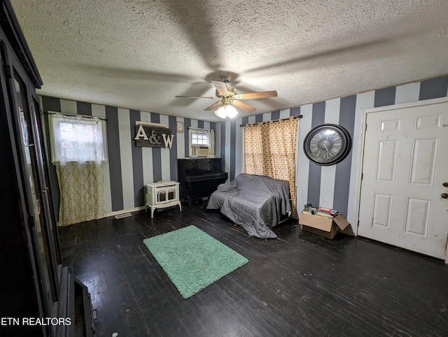 unfurnished bedroom featuring ceiling fan, dark hardwood / wood-style floors, a textured ceiling, and multiple windows