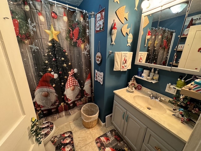 bathroom featuring toilet, tile patterned flooring, vanity, and walk in shower