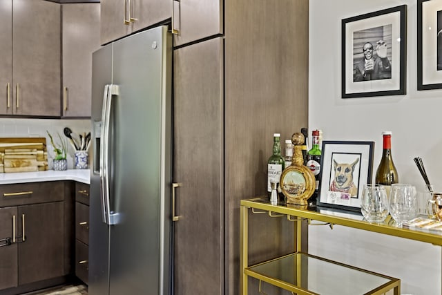 kitchen featuring dark brown cabinets and stainless steel fridge