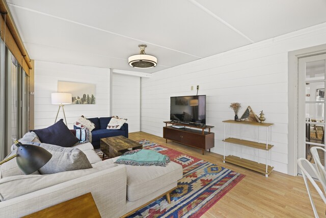 living room with wood-type flooring and wooden walls