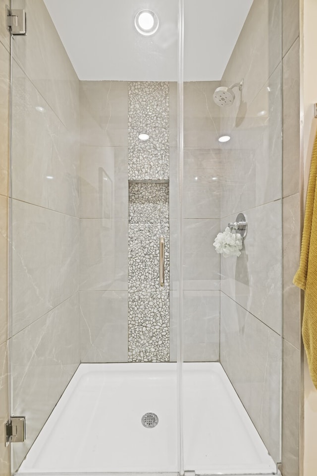 bathroom featuring a shower with shower door