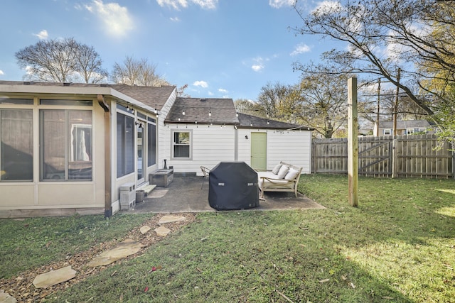 back of property featuring a sunroom, a patio area, and a lawn