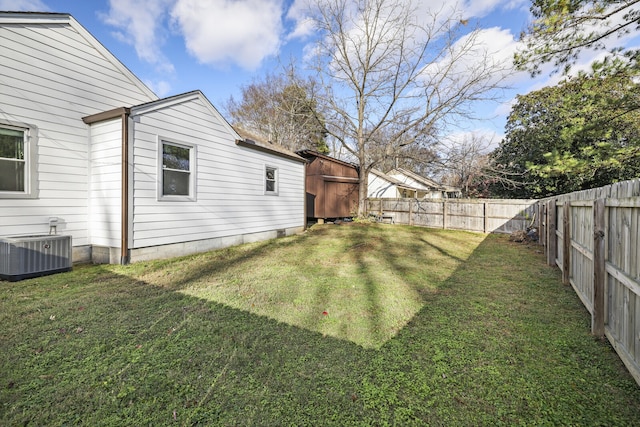 view of yard featuring central AC unit and a storage unit