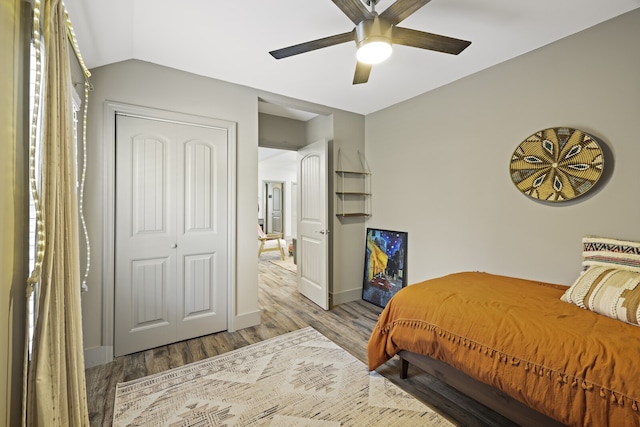 bedroom featuring hardwood / wood-style floors, a closet, ceiling fan, and lofted ceiling