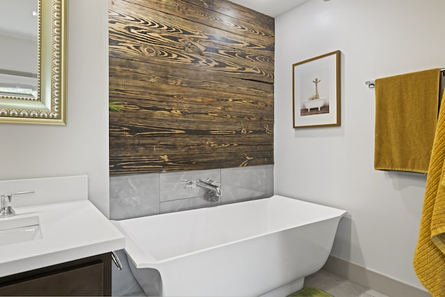 bathroom with a tub to relax in, tile patterned floors, and vanity