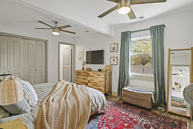 bedroom with ceiling fan, hardwood / wood-style floors, and beamed ceiling