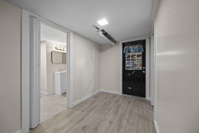 hallway featuring sink and light wood-type flooring