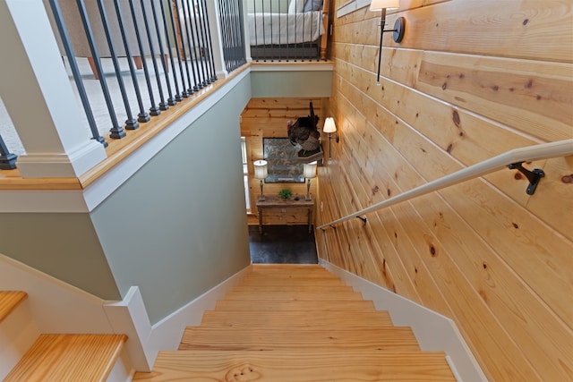 stairs with hardwood / wood-style flooring and wood walls