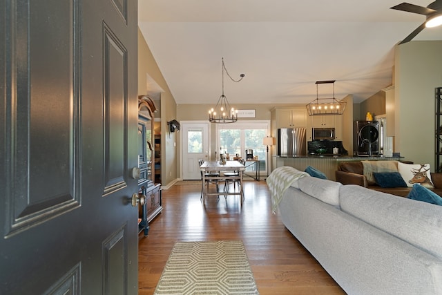 living room with ceiling fan with notable chandelier and light wood-type flooring