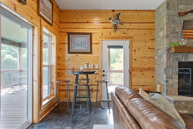 interior space featuring a stone fireplace and wood walls