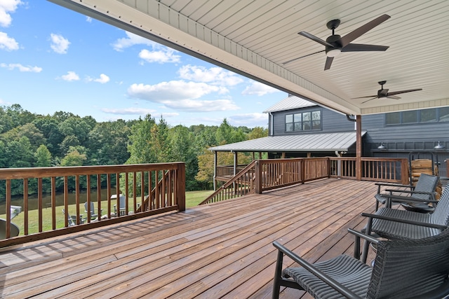 wooden terrace with ceiling fan and a lawn