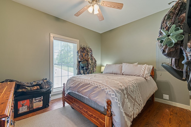 bedroom with dark hardwood / wood-style flooring and ceiling fan