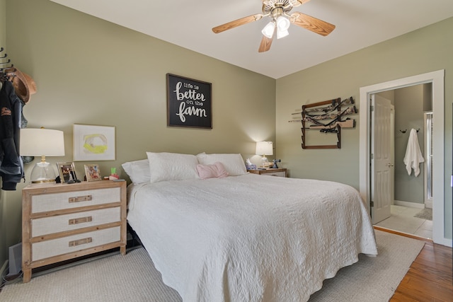 bedroom with ensuite bath, ceiling fan, and light hardwood / wood-style flooring